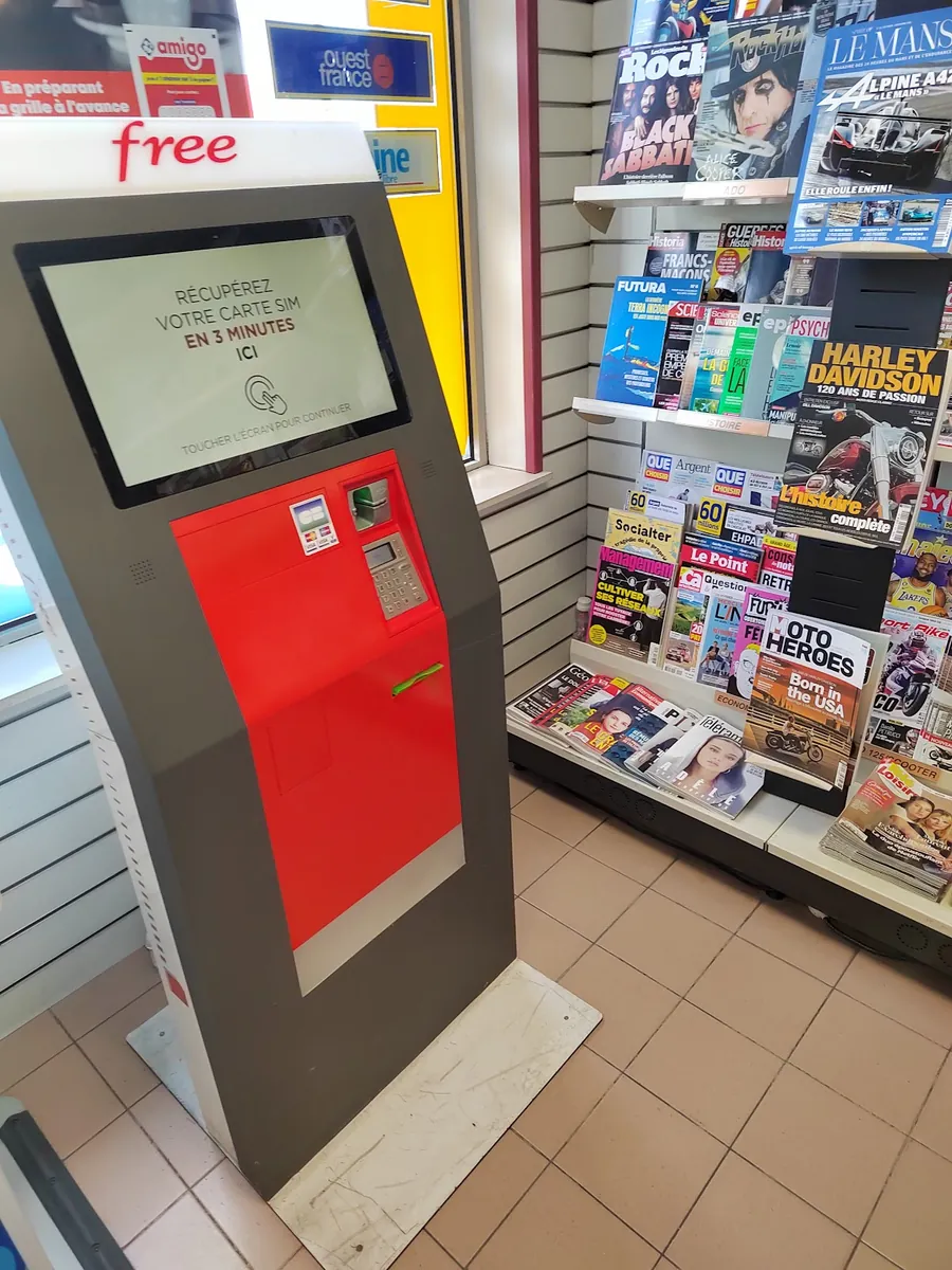 Dans la boutique, la borne Free rouge et les présentoirs de magazines